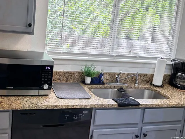 a kitchen with granite countertop cabinets and window