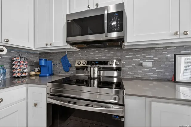 a kitchen with stainless steel appliances granite countertop a stove and a microwave
