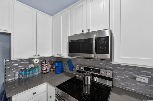 a kitchen with stainless steel appliances granite countertop a stove a microwave and a sink