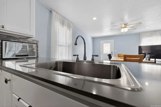 a living room with furniture a flat screen tv and kitchen area
