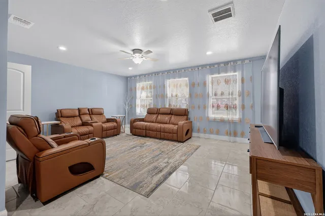 a living room with furniture a flat screen tv and a window