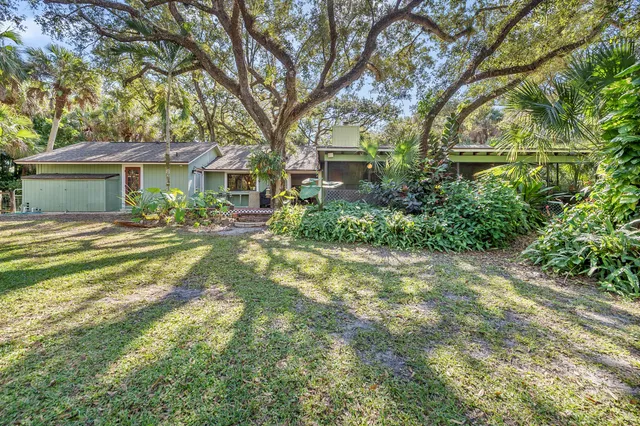a front view of a house with yard and green space