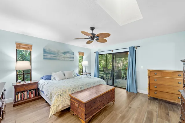 a spacious bedroom with a bed a dresser and a chandelier