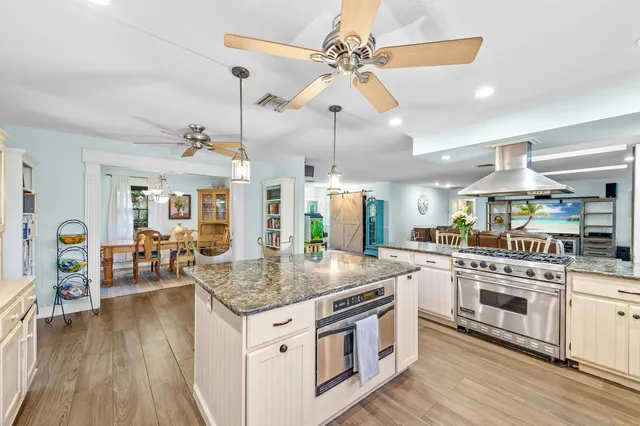 a kitchen with stainless steel appliances granite countertop a lot of counter space and wooden floors