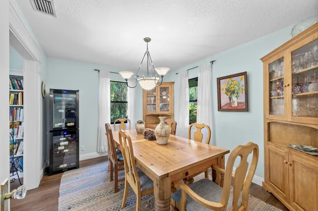 a dining room with furniture a chandelier and wooden floor