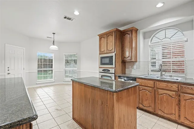 a kitchen with stainless steel appliances granite countertop a stove microwave and cabinets