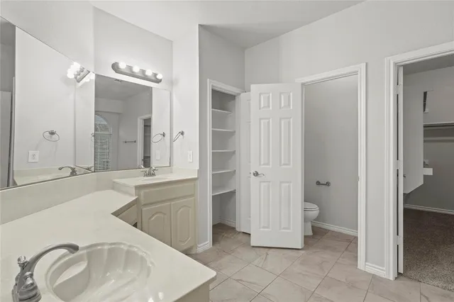 an empty room with windows and ceiling fan