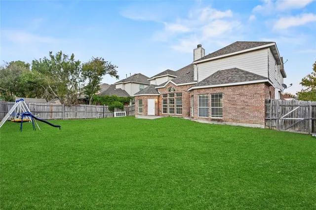 a view of a house with a big yard and large trees