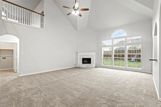 a view of an empty room with a fireplace and a window