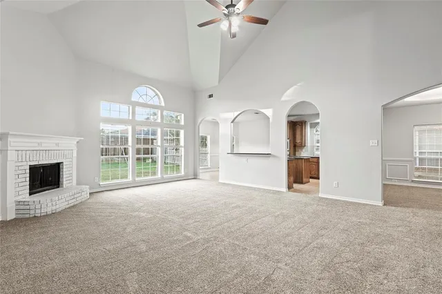 a view of an empty room with a fireplace and a window