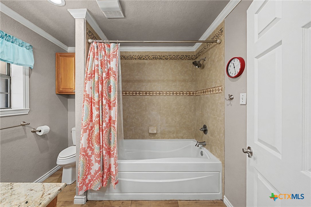 1601 Sunset Circle Cameron, TX 76520 - Photo 29 of 40 a bathroom with a shower curtain and a window
