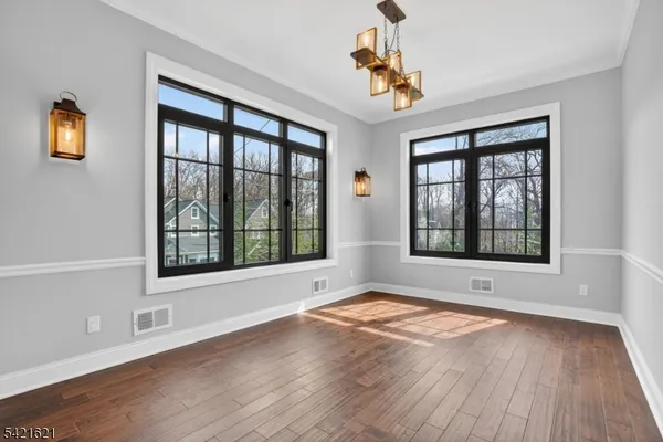 a kitchen with stainless steel appliances granite countertop a refrigerator a stove a sink and white cabinets with wooden floor