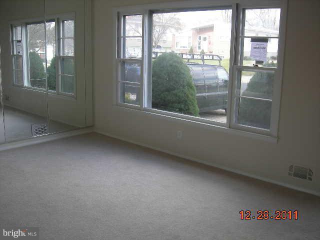 3317 Kenjac Road Windsor Mill, MD 21244 - Photo 10 of 12 an empty room with wooden floor and windows