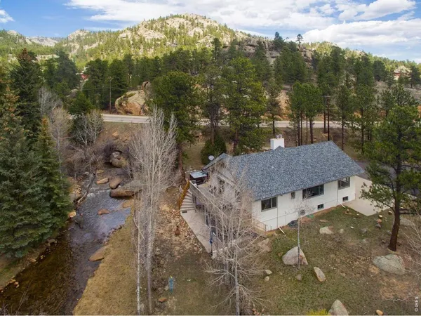 a aerial view of a house with a yard and mountain view