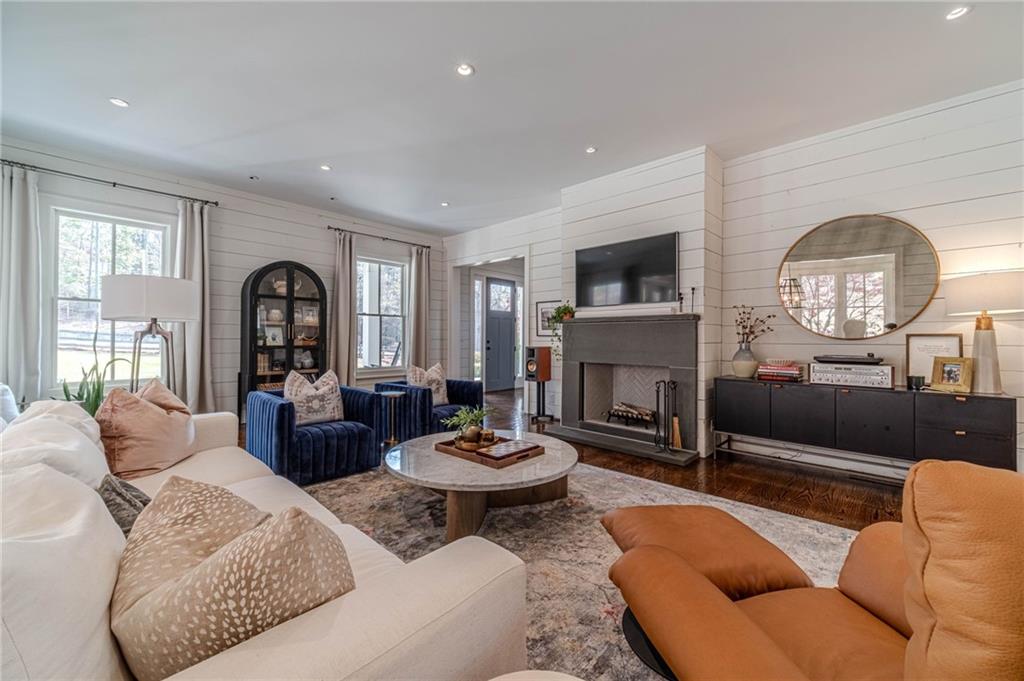 220 Audreys Way Suwanee, GA 30024 - Photo 14 of 66 a living room with furniture a fireplace and a flat screen tv