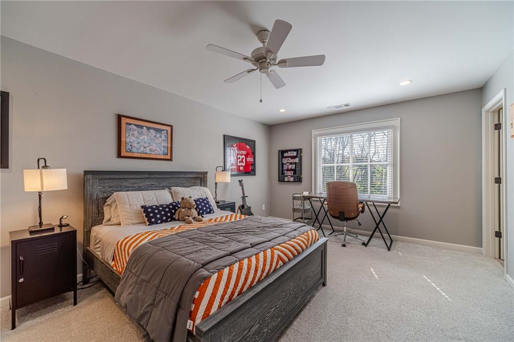 220 Audreys Way Suwanee, GA 30024 - Photo 41 of 66 a bedroom with bed and a chandelier