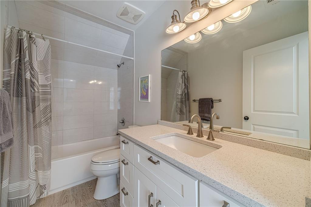 220 Audreys Way Suwanee, GA 30024 - Photo 42 of 66 a bathroom with a granite countertop sink a toilet and shower