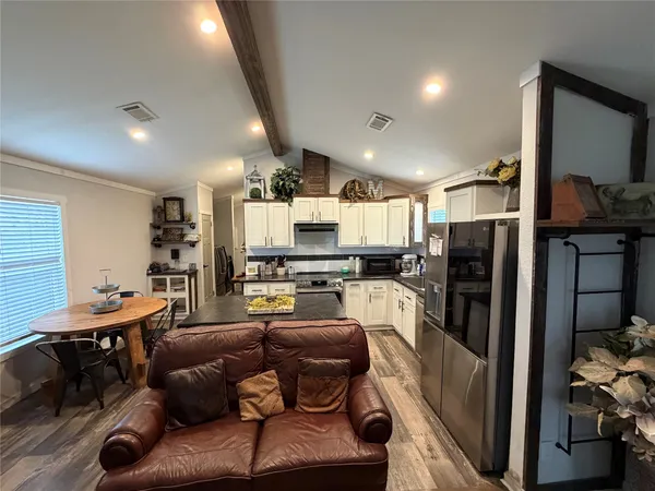 a living room with lots of furniture and kitchen view