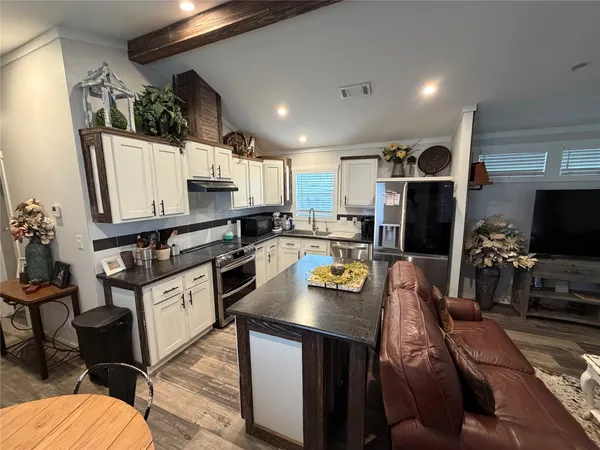 a kitchen with white cabinets and stainless steel appliances