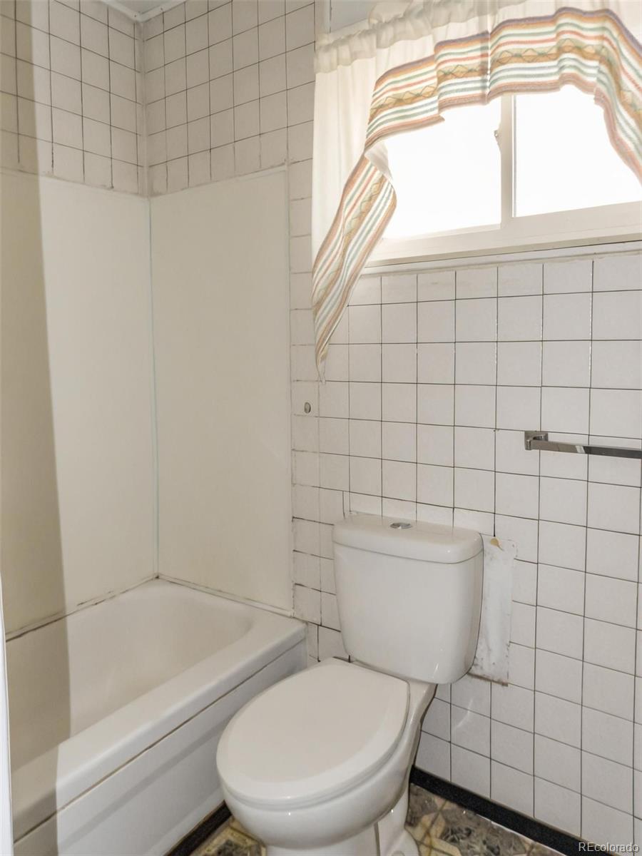 910 Elm Street Pueblo, CO 81004 - Photo 6 of 17 a white toilet sitting next to a bath tub and shower