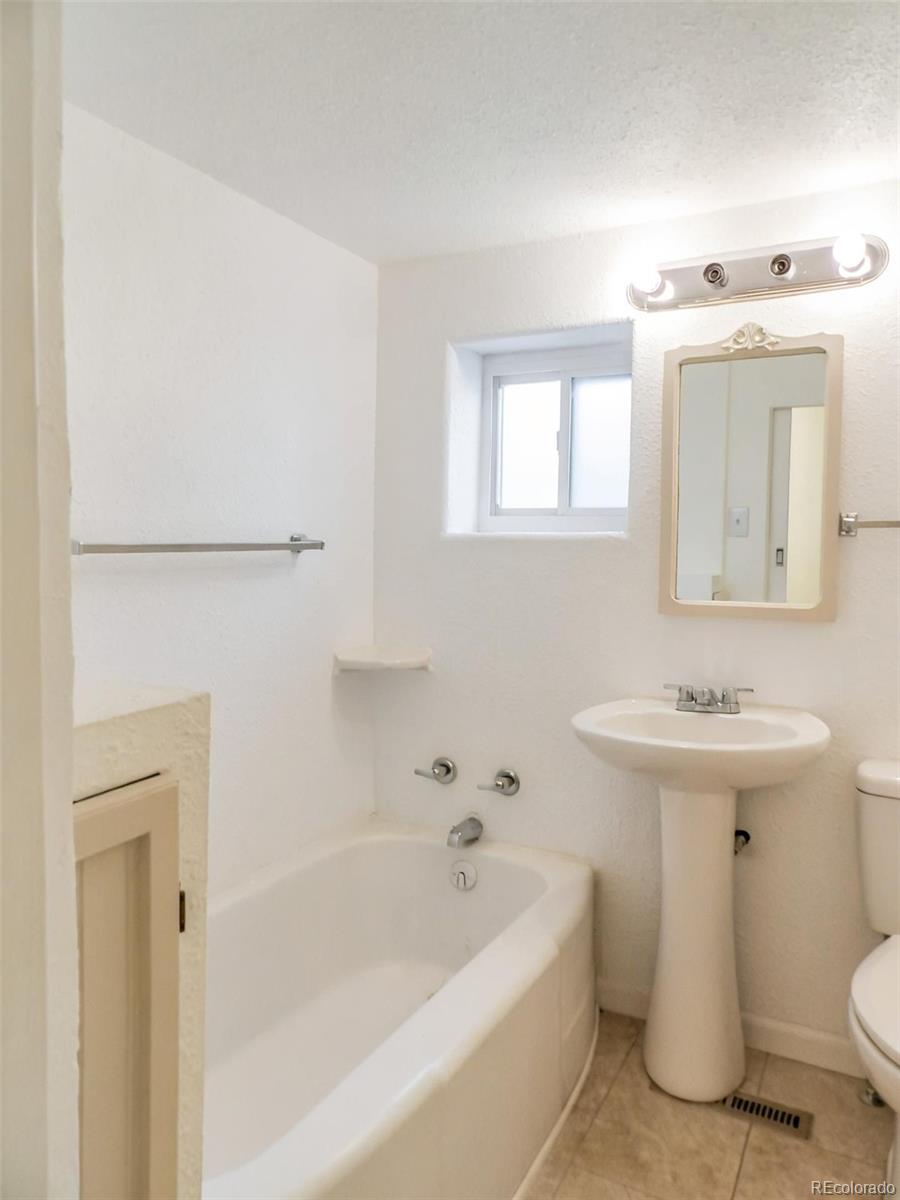910 Elm Street Pueblo, CO 81004 - Photo 8 of 17 a bathroom with a sink a toilet and a bathtub