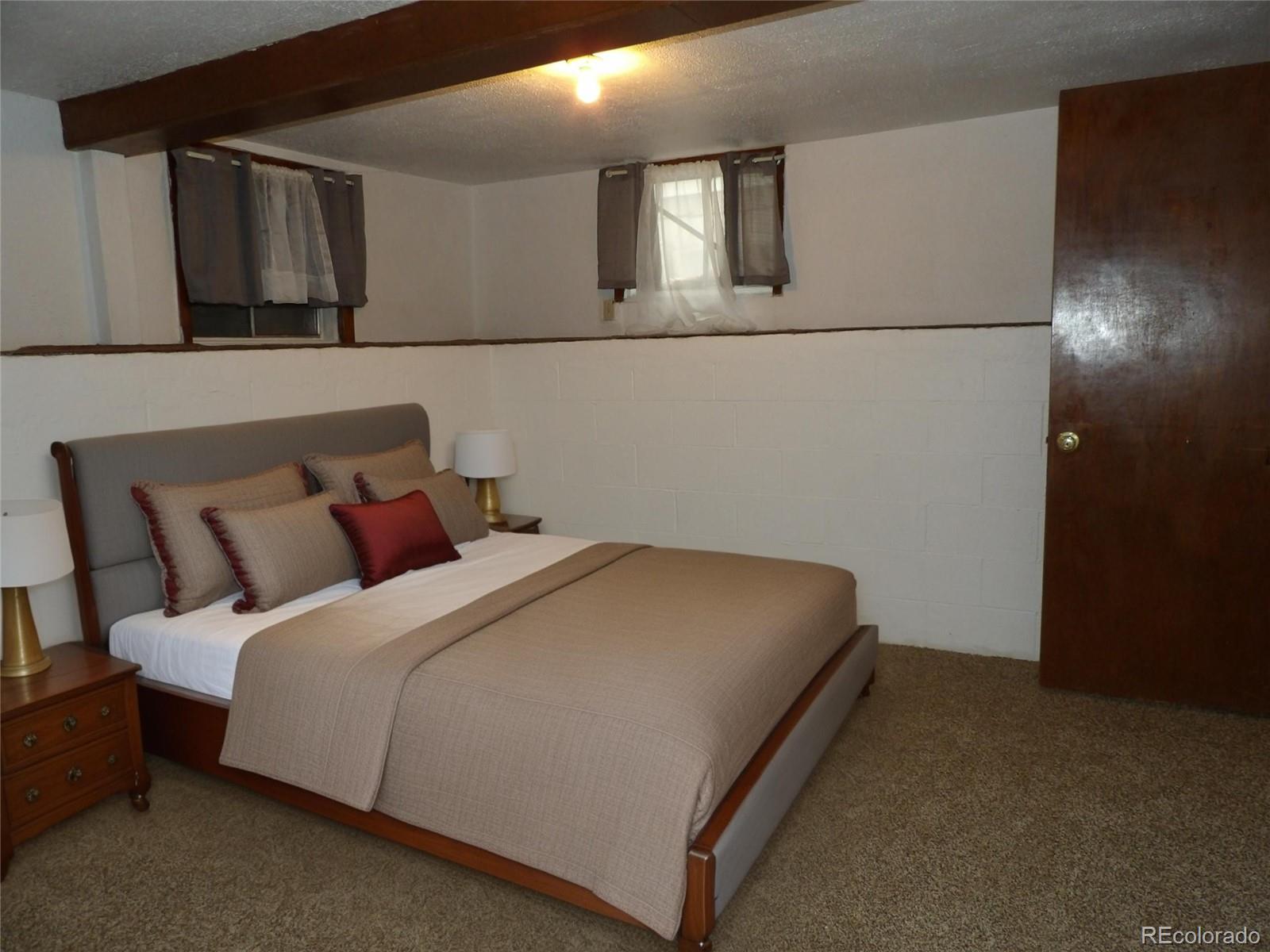 910 Elm Street Pueblo, CO 81004 - Photo 10 of 17 a bed room with a bed and painting on the wall