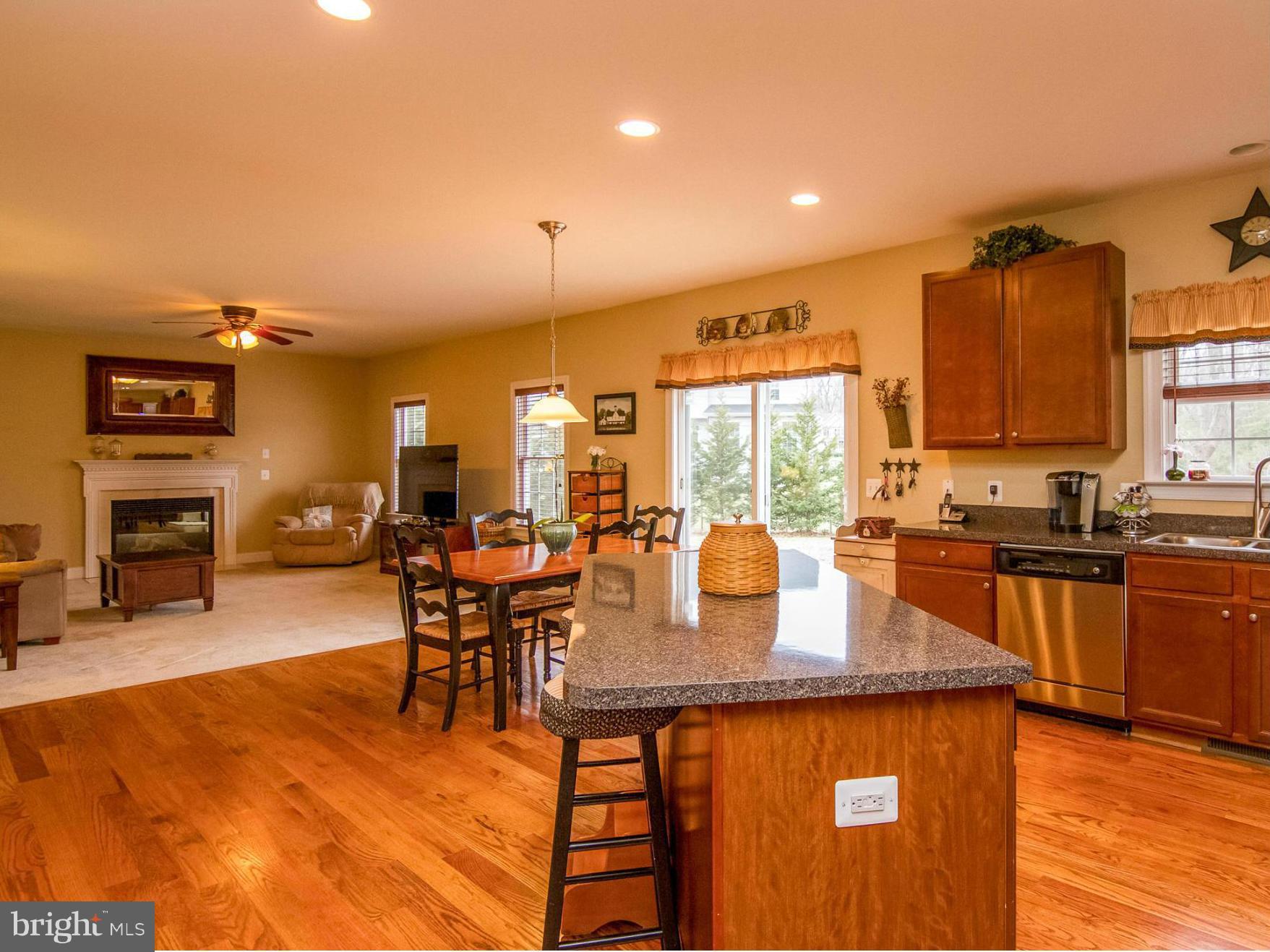4021 Brummel Road Pasadena, MD 21122 - Photo 11 of 27 a dining hall with stainless steel appliances granite countertop a stove top oven a dining table and chairs with wooden floor