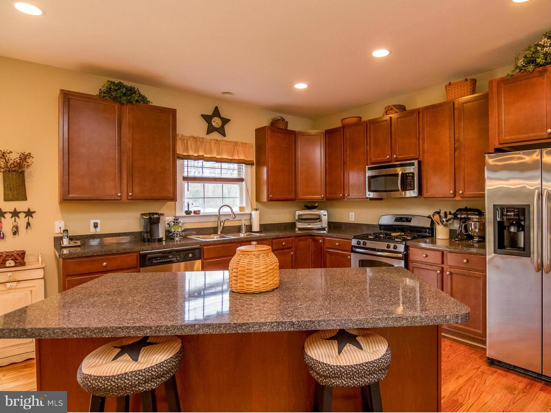 4021 Brummel Road Pasadena, MD 21122 - Photo 3 of 27 a kitchen with stainless steel appliances granite countertop a table chairs sink refrigerator and microwave