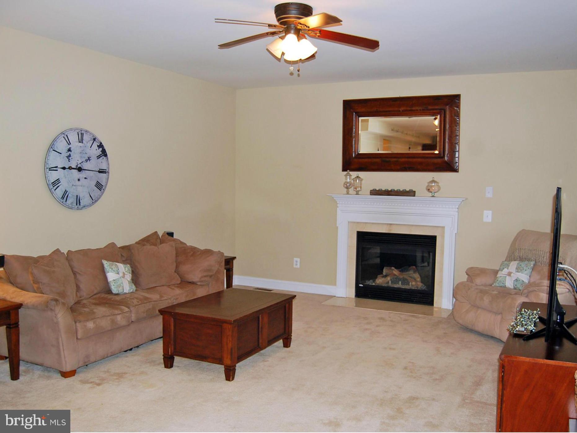 4021 Brummel Road Pasadena, MD 21122 - Photo 5 of 27 a living room with furniture a fireplace and a flat screen tv