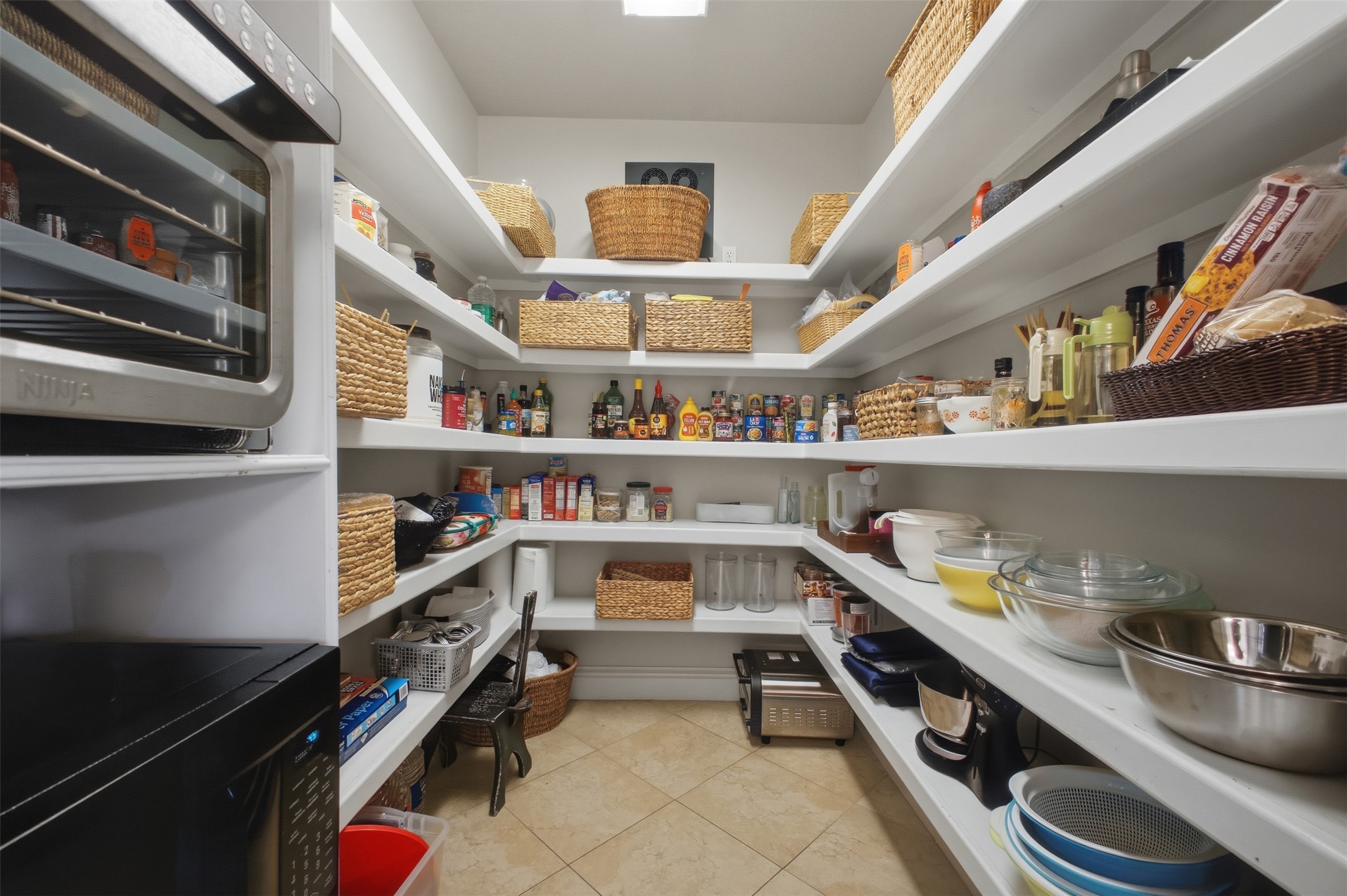 12710 Aries Loop Willis, TX 77318 - Photo 14 of 40 Spacious pantry featuring extensive white shelving, tiled flooring, and an integrated appliance