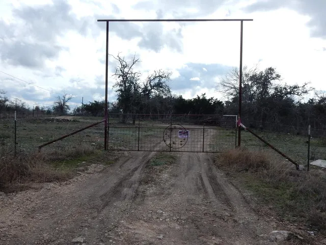 a view of a yard with wooden fence