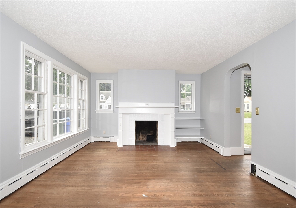 17 Old Brook Road Springfield, MA 01118 - Photo 9 of 23 a view of empty room with wooden floor and fireplace
