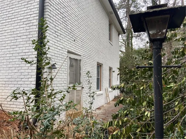a backyard of a house with table and chairs and potted plants