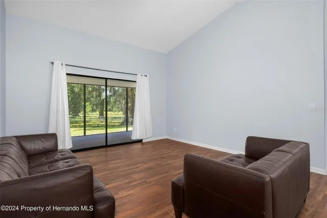 a view of empty room with wooden floor and window