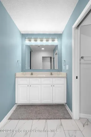 an empty room with wooden floor chandelier fan and windows