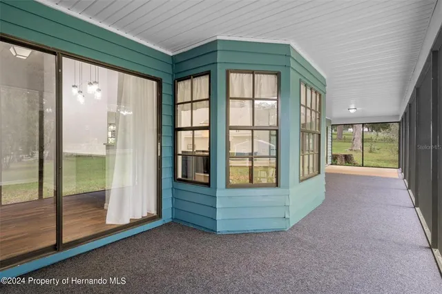 a big yard with lots of green space and trees in the back