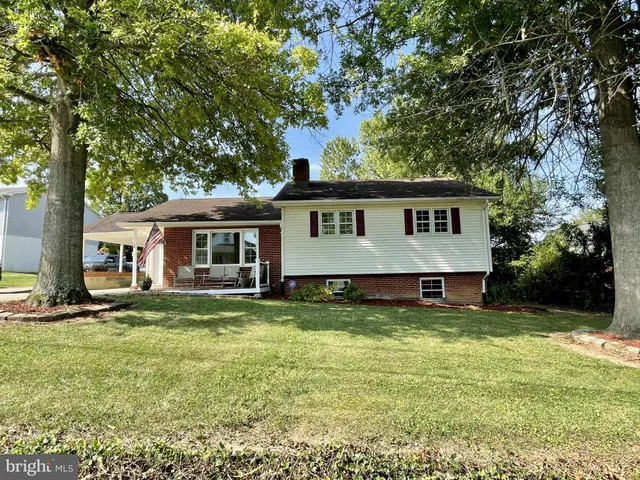 a view of a house with a big yard and large trees