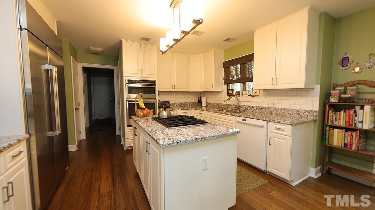 7300 Rainwater Road Raleigh, NC 27615 - Photo 6 of 18 a kitchen with granite countertop a sink stove and cabinets