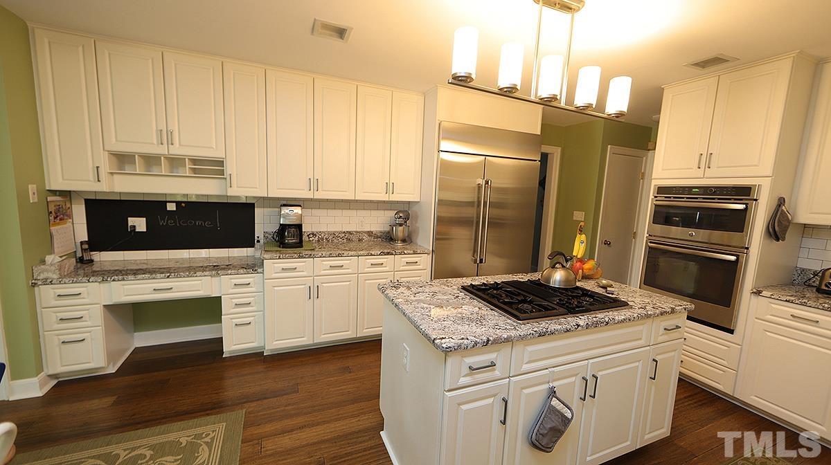 7300 Rainwater Road Raleigh, NC 27615 - Photo 7 of 18 a kitchen with granite countertop white cabinets and refrigerator