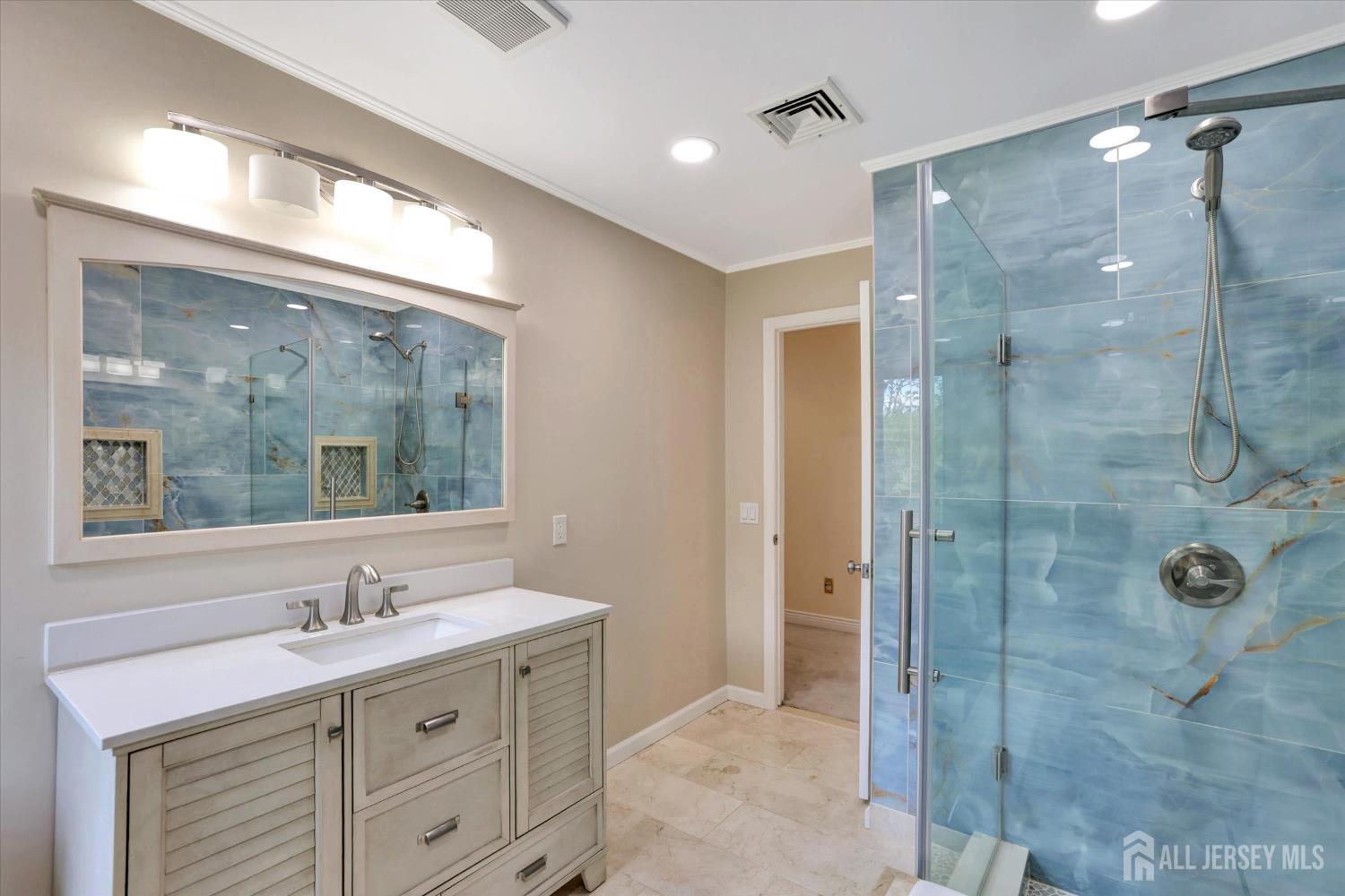 403 New Dover Road Colonia, NJ 07067 - Photo 30 of 51 a bathroom with a shower sink and mirror