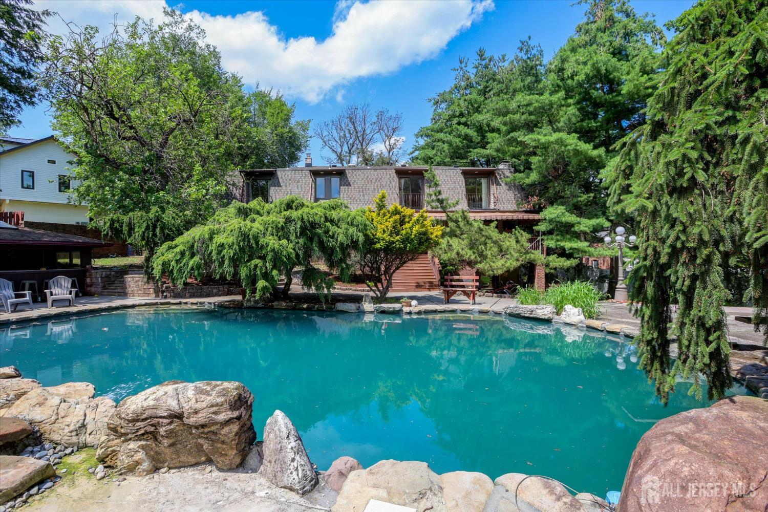 403 New Dover Road Colonia, NJ 07067 - Photo 44 of 51 a view of a lake with a garden and swimming pool