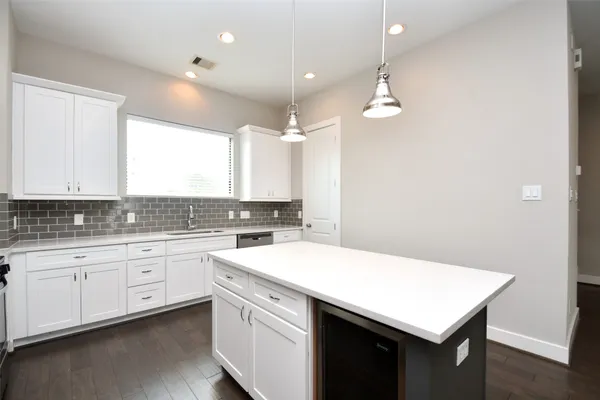 a kitchen with a sink a stove a refrigerator and white cabinets