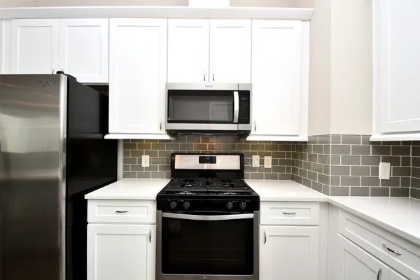 a kitchen with granite countertop a stove and a microwave