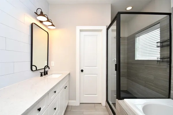 a bathroom with a double vanity sink a mirror and shower
