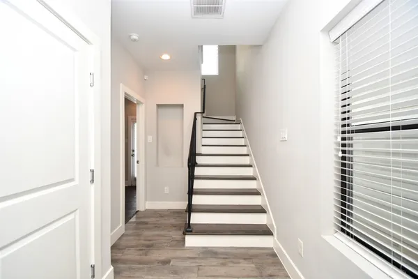 a view of a hallway with wooden floor and entryway
