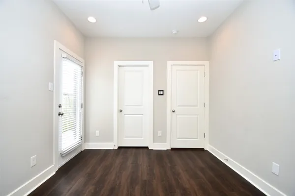 an empty room with wooden floor and window