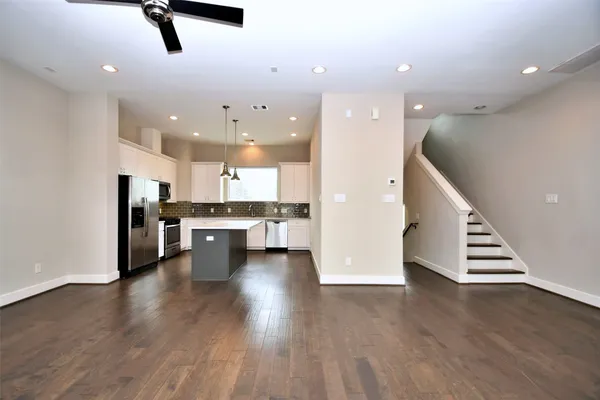 a view of kitchen with stainless steel appliances refrigerator oven stove and white cabinets