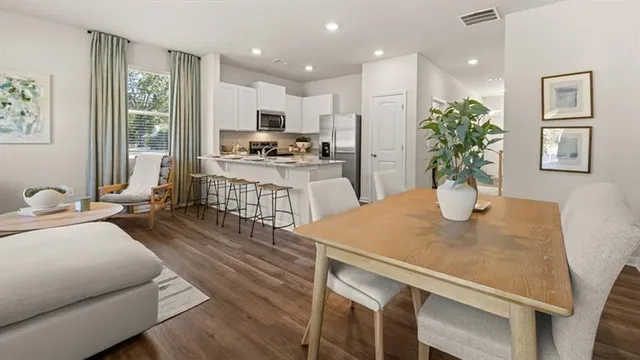 a kitchen with a table chairs refrigerator and microwave