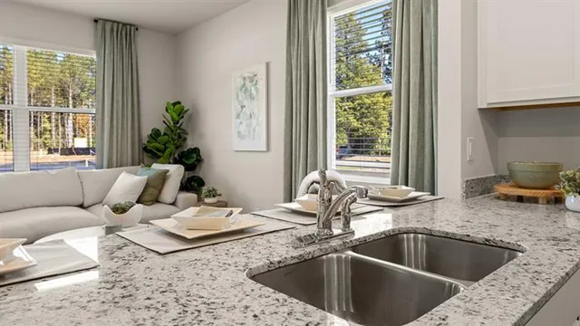 a kitchen with a granite countertop sink and natural light