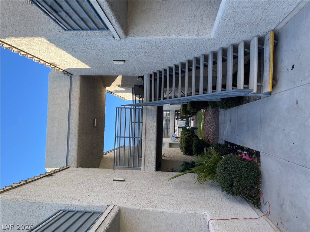 6250 West Flamingo Road, Unit 142 Las Vegas, NV 89103 - Photo 3 of 3 A stucco exterior with tiled roofing and well-maintained shrubbery creates a welcoming entrance.